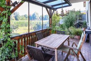 einen Holztisch und Stühle auf dem Balkon eines Hauses in der Unterkunft Breubergblick, Stylisches Apartment in Breuberg in Breuberg