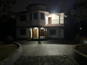 a white house at night with a light on it at Souparnika Homestay in Kannur