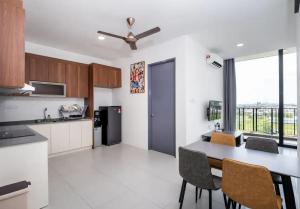 cocina con mesa y sillas en una habitación en APARTMENTS @ PODIUM, KUCHING en Kuching