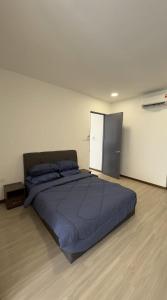 ein Schlafzimmer mit einem großen blauen Bett und einem Kühlschrank in der Unterkunft APARTMENTS @ PODIUM, KUCHING in Kuching