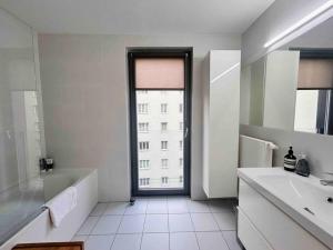 ein Bad mit einer Badewanne, einem Waschbecken und einem Fenster in der Unterkunft Comfortable living in our spacious home in Wien