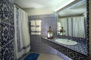 a blue and white bathroom with a sink and a mirror at Hotel Chellah in Tangier