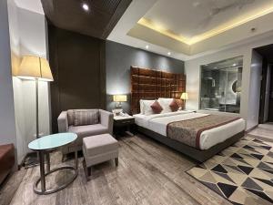 una camera con letto, sedia e tavolo di Hotel Sand Heaven a Port Blair