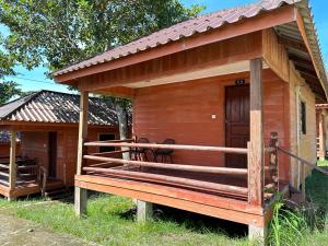 Cabaña de madera pequeña con porche y puerta en Koh RhongSunshine Resort, en Phumĭ Kaôh Rŏng