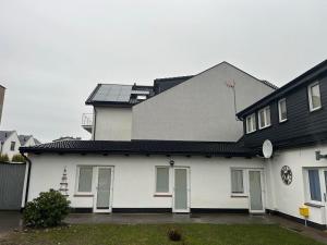 ein weißes Haus mit schwarzem Dach in der Unterkunft Nadmorska Ostoya in Władysławowo