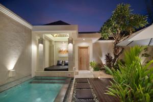 a villa with a swimming pool at night at The Seiryu Boutique Bali Villas in Seminyak