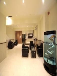 a living room with a fish tank in the middle at Hotel Pine Tree in Rajkot
