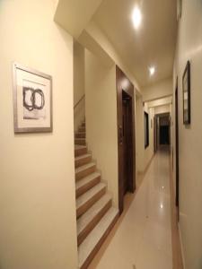 a hallway with stairs and a picture on the wall at Hotel Pine Tree in Rajkot