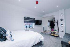 a bedroom with a large white bed and a window at Modern Studio Hindley in Hindley