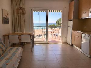 a kitchen and living room with a view of the ocean at Apartaments Les Roques in Platja  d'Aro