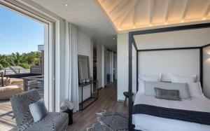una camera con un grande letto e un balcone di Luxury Vacation Villa 21 a Petit Cul de Sac
