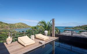 - une table en bois avec deux oreillers au-dessus de la piscine dans l'établissement Luxury Vacation Villa 21, à Petit Cul de Sac