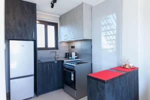 a kitchen with gray cabinets and a red counter top at Marousi Modern Green Oasis Apt w Amazing Balcony in Athens