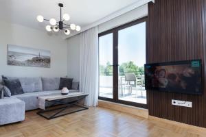 a living room with a couch and a flat screen tv at Marousi Modern Green Oasis Apt w Amazing Balcony in Athens