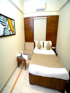 a hotel room with a bed and a table at Hotel Pine Tree in Rajkot