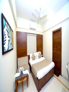 Hotel Pine Tree في راجكوت: غرفة الفندق بسرير وطاولة