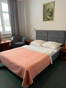 a hotel room with a bed and a chair at Alabastro in Tomaszów Mazowiecki