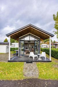 - un pavillon avec une table et deux chaises blanches dans l'établissement Amici Camping Urlaub am Effelder Waldsee, à Wassenberg