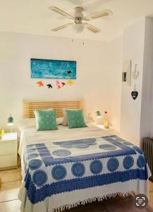 1 dormitorio con 1 cama con edredón azul y blanco en Estupendo Apartamento Urbanizacion Jardines de Zahara. Zahara de los Atunes, en Zahara de los Atunes