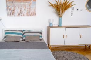 a bedroom with a bed and a white cabinet at Tiffany Apartment in Novi Sad