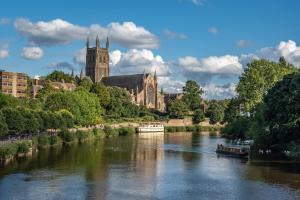 a river in front of a city with a cathedral at WhiskAwayStays - Shaw Street - Character city centre apartment in Worcester