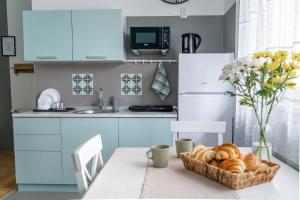 a kitchen with a table with a basket of bread at Tiffany Apartment in Novi Sad