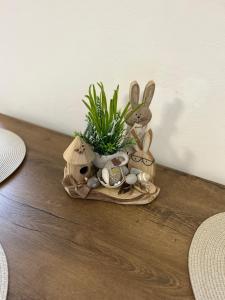 eine Platte mit Kaninchen und eine Pflanze auf dem Tisch in der Unterkunft APARTMENT OWL in Kořenov