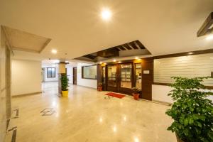 un vestíbulo vacío con macetas en un edificio en Midtown Suites Marathahalli Bangalore, en Bangalore