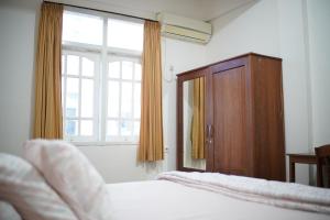 a bedroom with a bed and a window and a cabinet at Wisma Grace in Ambon