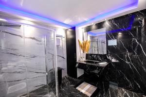 La salle de bains est pourvue d'une douche, d'un lavabo et d'un miroir. dans l'établissement Beach Blue Villa, à Corinthe