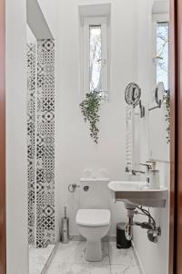 a white bathroom with a toilet and a sink at Nest Boutique Hostel in Bucharest