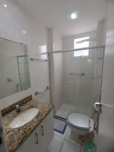 a bathroom with a shower and a toilet and a sink at Apartamento 2 quartos Prédio frente Para o Mar início da Praia do Morro in Guarapari