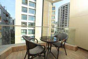 a balcony with two chairs and a glass table at Britannia Suites in Beirut