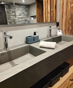 a kitchen with two sinks and a counter top at Chalet Pura Vida - En pleine nature, tout confort in Le Valtin