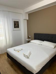 a bedroom with a large white bed with towels on it at Titina Suites Apartment Rome in Rome