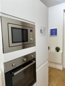 um micro-ondas na cozinha com paredes brancas em Titina Suites Apartment Rome em Roma