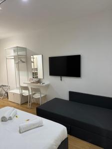 a living room with a bed and a flat screen tv at Titina Suites Apartment Rome in Rome