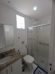 a bathroom with a toilet and a shower and a sink at Apartamento 2 quartos Prédio frente Para o Mar início da Praia do Morro in Guarapari