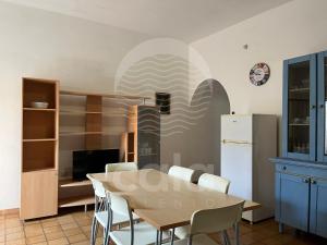 a dining room with a table and chairs and a refrigerator at Villetta Zora - Spiaggia a 250m in Porto Cesareo