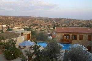 a house with a swimming pool and an umbrella at Eveleos Country House in Tochni