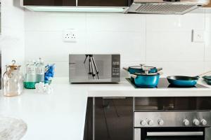 a kitchen with a microwave and two bowls on a counter at Azure Escape - Power backup in Sandton