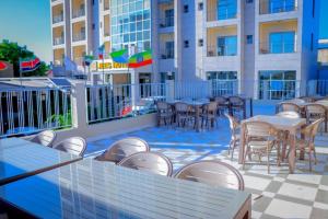 - un ensemble de tables et de chaises sur une terrasse dans l'établissement Jees Hotel, à Hargeisa