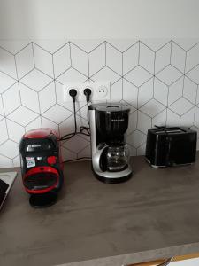 a kitchen counter with a coffee maker and a toaster at Les Magnolias in Tourville-la-Chapelle