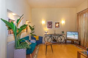a living room with a blue couch and a tv at Hotel Villa Benvenuti in Viareggio