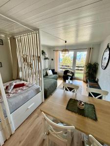 a living room with a bed and a table at Vue imprenable sur les Alpes et Parking privé gratuit in Crans-Montana