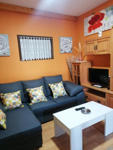 a living room with a blue couch and a table at NIDO in Ribadeo