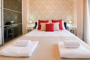 a bedroom with a large white bed with red pillows at Beach Blue Villa in Korinthos