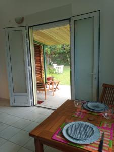 ein Esszimmer mit einem Tisch und einer Glasschiebetür in der Unterkunft Ti Kaz citron in Sainte-Rose