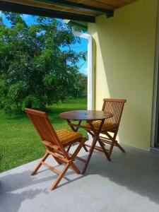 2 Stühle und ein Tisch auf der Terrasse in der Unterkunft Ti Kaz citron in Sainte-Rose