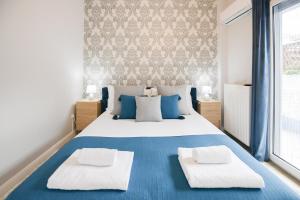 um quarto com uma cama azul e branca com 2 almofadas em Beach Blue Villa em Corinto